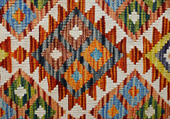 Handwoven Afghan Maimana kilim featuring a vibrant geometric diamond pattern in wool.