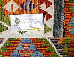 A handwoven Afghan Maimana kilim featuring a vibrant geometric pattern in wool.
