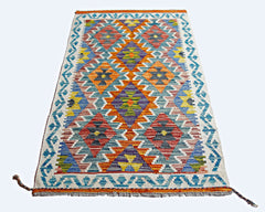A rectangular Afghan Maimana kilim featuring a vibrant geometric diamond pattern in wool.