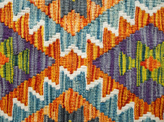 Handwoven Afghan Maimana kilim featuring a vibrant geometric pattern in wool.