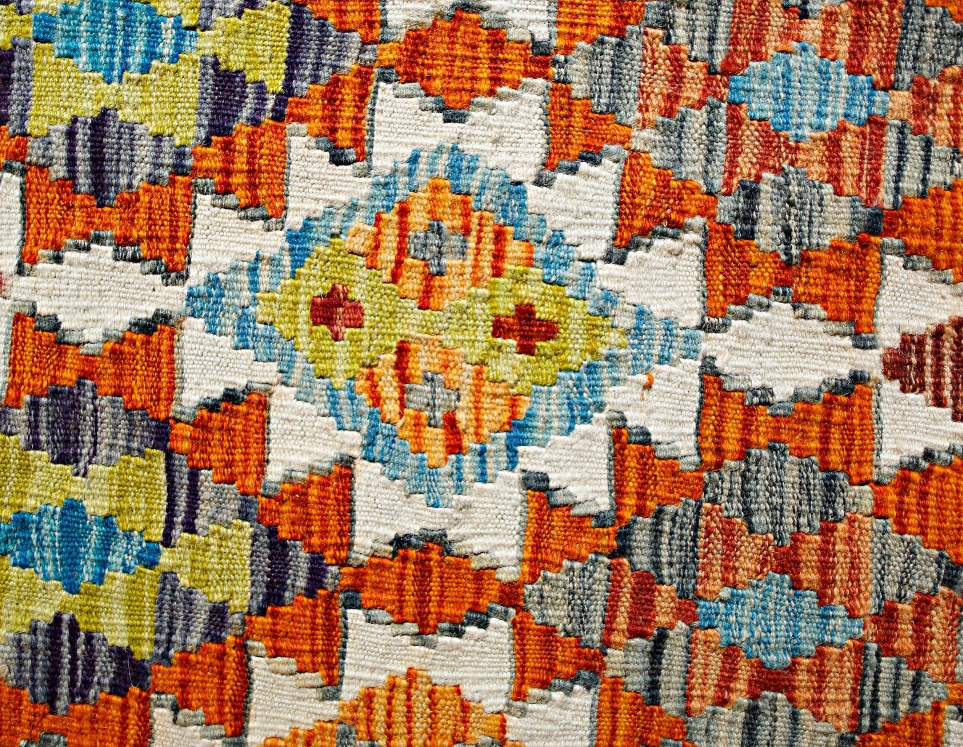 Handwoven Afghan Maimana kilim featuring a vibrant geometric pattern in wool.