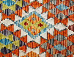 Handwoven Afghan Maimana kilim featuring a vibrant geometric pattern in wool.