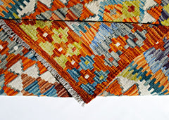 A handwoven Afghan Maimana kilim rug featuring a vibrant geometric pattern in wool.