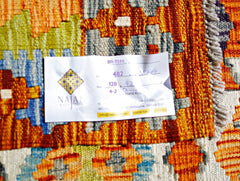 A handmade Afghan Maimana kilim featuring a vibrant geometric pattern in orange and blue tones.