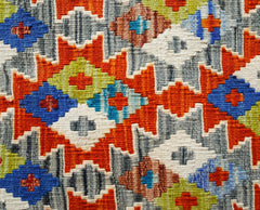 Handwoven Afghan Maimana kilim featuring a vibrant geometric pattern in wool.