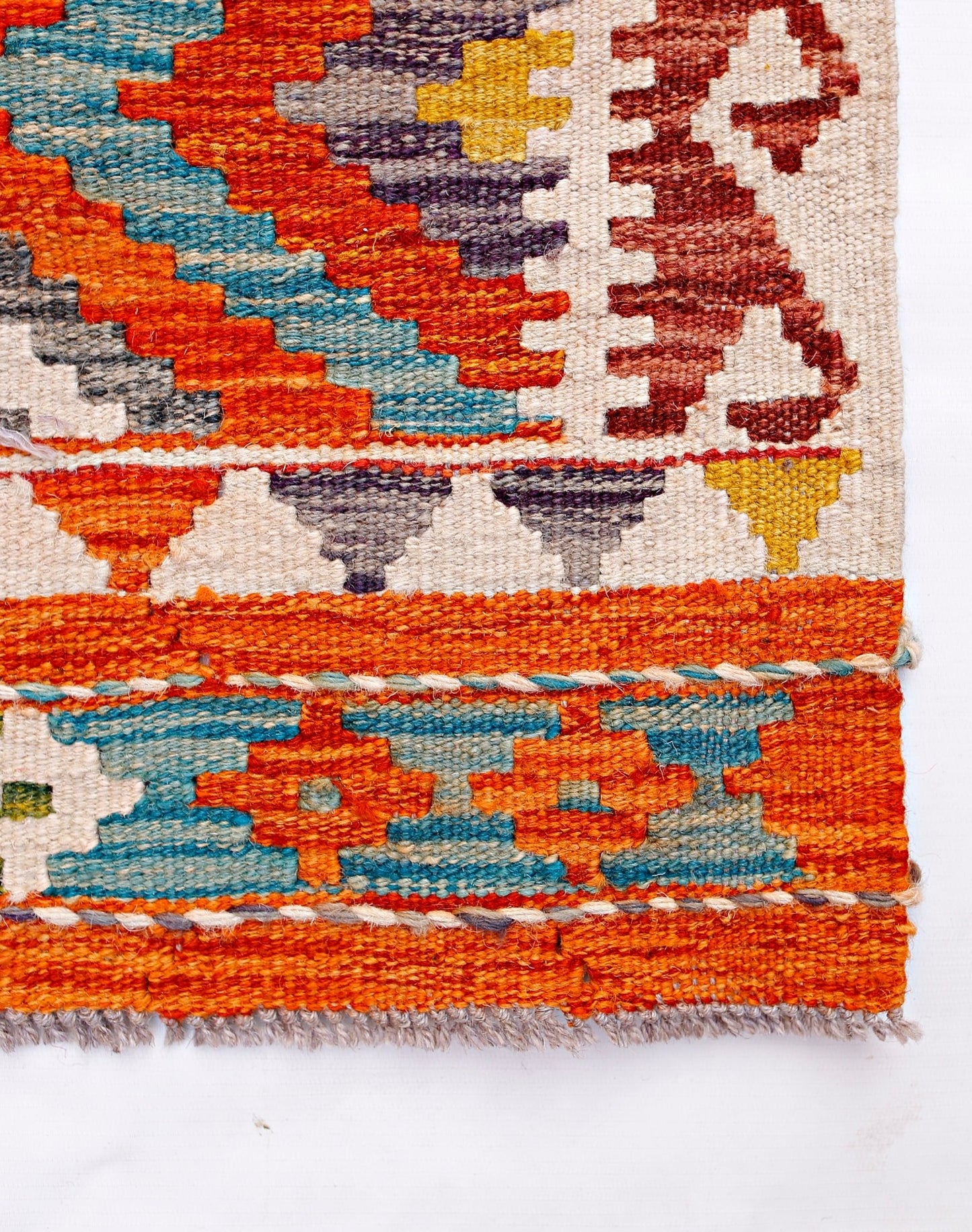 Handwoven Afghan Maimana kilim featuring geometric patterns in vibrant orange, blue, and yellow.