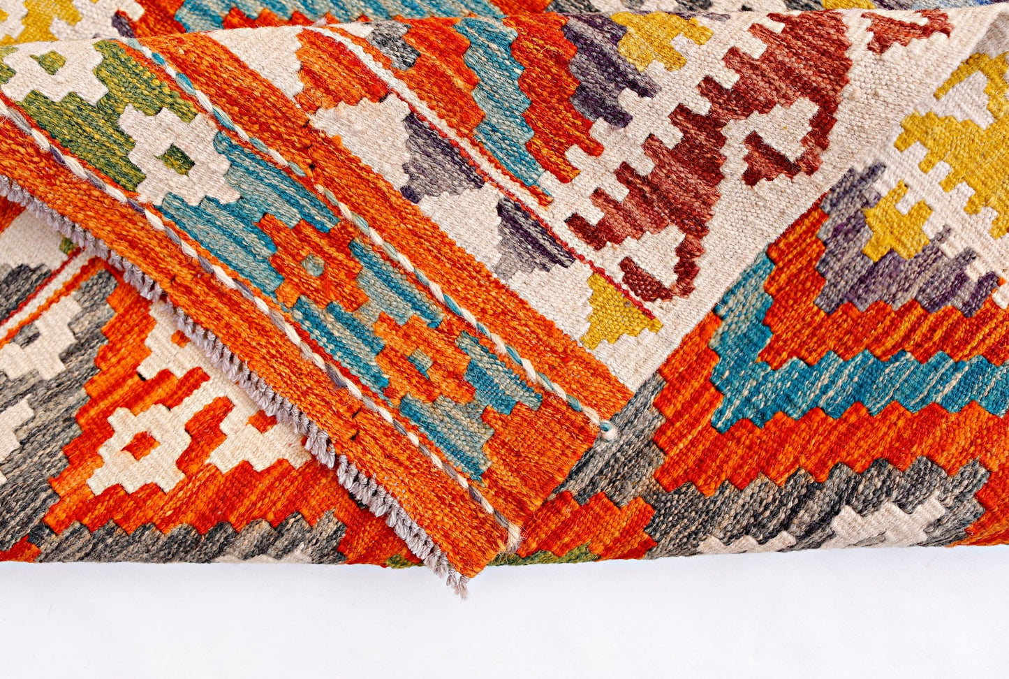 A handwoven Afghan Maimana kilim rug featuring a vibrant geometric pattern in wool.
