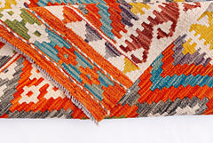 A handwoven Afghan Maimana kilim rug featuring a vibrant geometric pattern in wool.