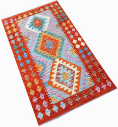Handwoven Afghan Maimana kilim rug featuring a geometric diamond pattern in vibrant colors.