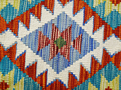 A close-up of a handmade Afghan Maimana kilim featuring a vibrant geometric diamond pattern.