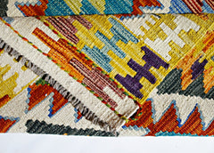 A close-up of a handwoven Afghan Maimana kilim featuring vibrant geometric patterns in wool.