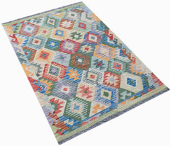 Handwoven Afghan Maimana kilim rug featuring a colorful geometric diamond pattern in wool.