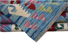 A handwoven Afghan Maimana kilim rug featuring a geometric pattern in blue, red, and pink wool.