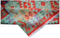 A handwoven Afghan Maimana kilim rug featuring geometric patterns in red, blue, and green wool.