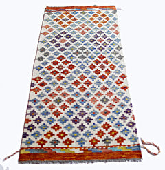 Handwoven Afghan Maimana kilim featuring a repeating geometric pattern in vibrant colors.