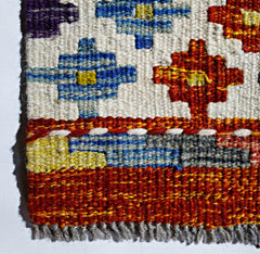 Handwoven Afghan Maimana kilim featuring geometric patterns in red, blue, and yellow wool.