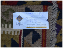 A handwoven Afghan Maimana kilim featuring a geometric pattern in rich, earthy tones.