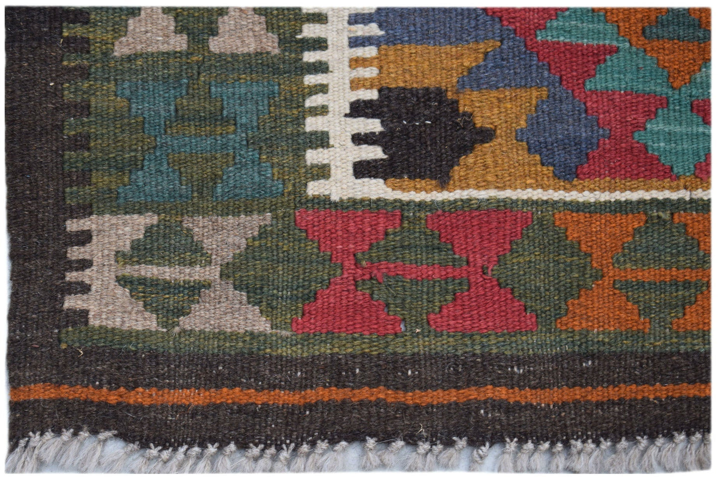 A handmade Afghan Maimana kilim rug featuring a geometric pattern in vibrant, multi-colored wool.