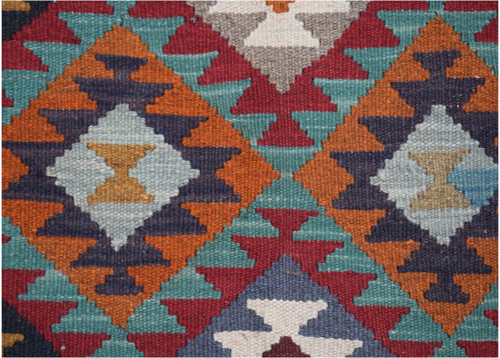 Handwoven Afghan Maimana kilim featuring a geometric diamond pattern in vibrant wool colors.