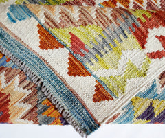 A handwoven Afghan Maimana kilim featuring a vibrant geometric pattern in wool.