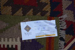 A handmade Afghan Maimana kilim featuring a geometric pattern in rich, earthy tones.