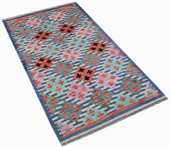Handwoven Afghan Maimana kilim rug featuring a geometric pattern in blue, pink, and orange wool.