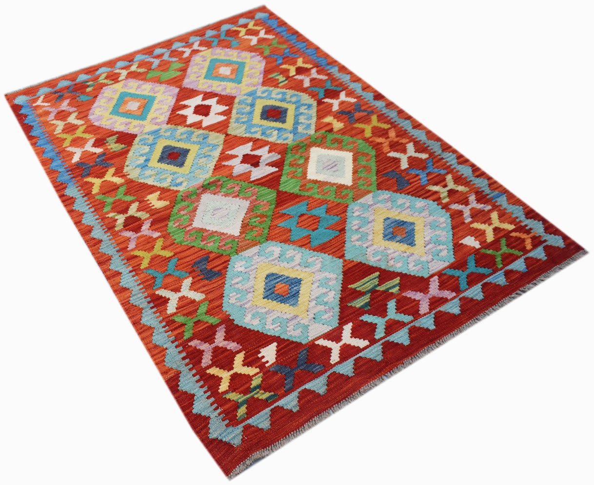 Handwoven Afghan Maimana kilim rug featuring a vibrant red background with geometric diamond motifs.