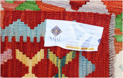 A close-up of a handwoven Afghan Maimana kilim featuring vibrant geometric patterns in wool.