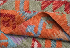 A handwoven Afghan Maimana kilim rug featuring a vibrant geometric pattern in wool.