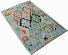 Handwoven Afghan Maimana kilim rug featuring a colorful geometric diamond pattern on a blue base.