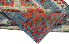 A handwoven Afghan Maimana kilim rug featuring a geometric pattern in red, blue, and green wool.