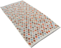 A handmade Afghan Maimana kilim rug featuring a repeating geometric pattern in orange, blue, and grey.