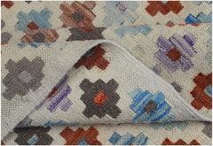 A handmade Afghan Maimana kilim rug featuring a geometric pattern in vibrant, multicolored wool.