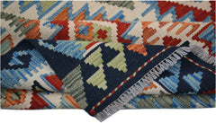 A handmade Afghan Maimana kilim rug featuring a geometric pattern in blue, red, and green wool.