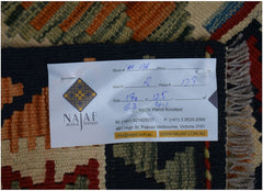 A handwoven Afghan Maimana kilim featuring a geometric pattern in rich, earthy tones.