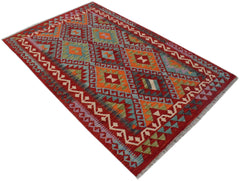 A rectangular Afghan Maimana kilim rug featuring a vibrant geometric pattern in wool.