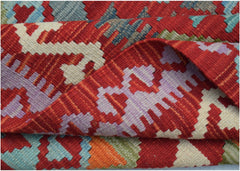 A handwoven Afghan Maimana kilim rug featuring a vibrant geometric pattern in wool.