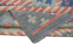 A handwoven Afghan Maimana kilim rug featuring a geometric pattern in blue, red, and cream wool.