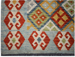 Handwoven Afghan Maimana kilim rug featuring geometric patterns in red, blue, yellow, and green.
