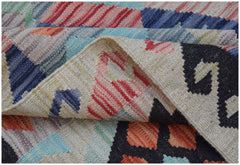 A handwoven Afghan Maimana kilim rug featuring a colorful geometric pattern and flatweave texture.