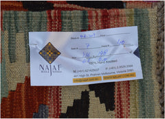 A handmade Afghan Maimana kilim featuring a geometric pattern in rich, warm colors.