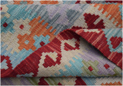 A handwoven Afghan Maimana kilim rug featuring a vibrant geometric pattern in wool.