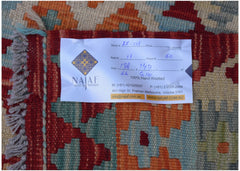 A handwoven Afghan Maimana kilim featuring a geometric pattern in red, orange, and blue tones.