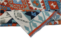 A handmade Afghan Maimana kilim rug featuring geometric patterns in orange, blue, and cream.