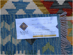 A handwoven Afghan Maimana kilim rug featuring a geometric pattern in blue, orange, and cream.
