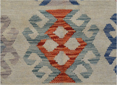 A close-up of an Afghan Maimana kilim featuring a geometric orange and blue pattern on a cream base.