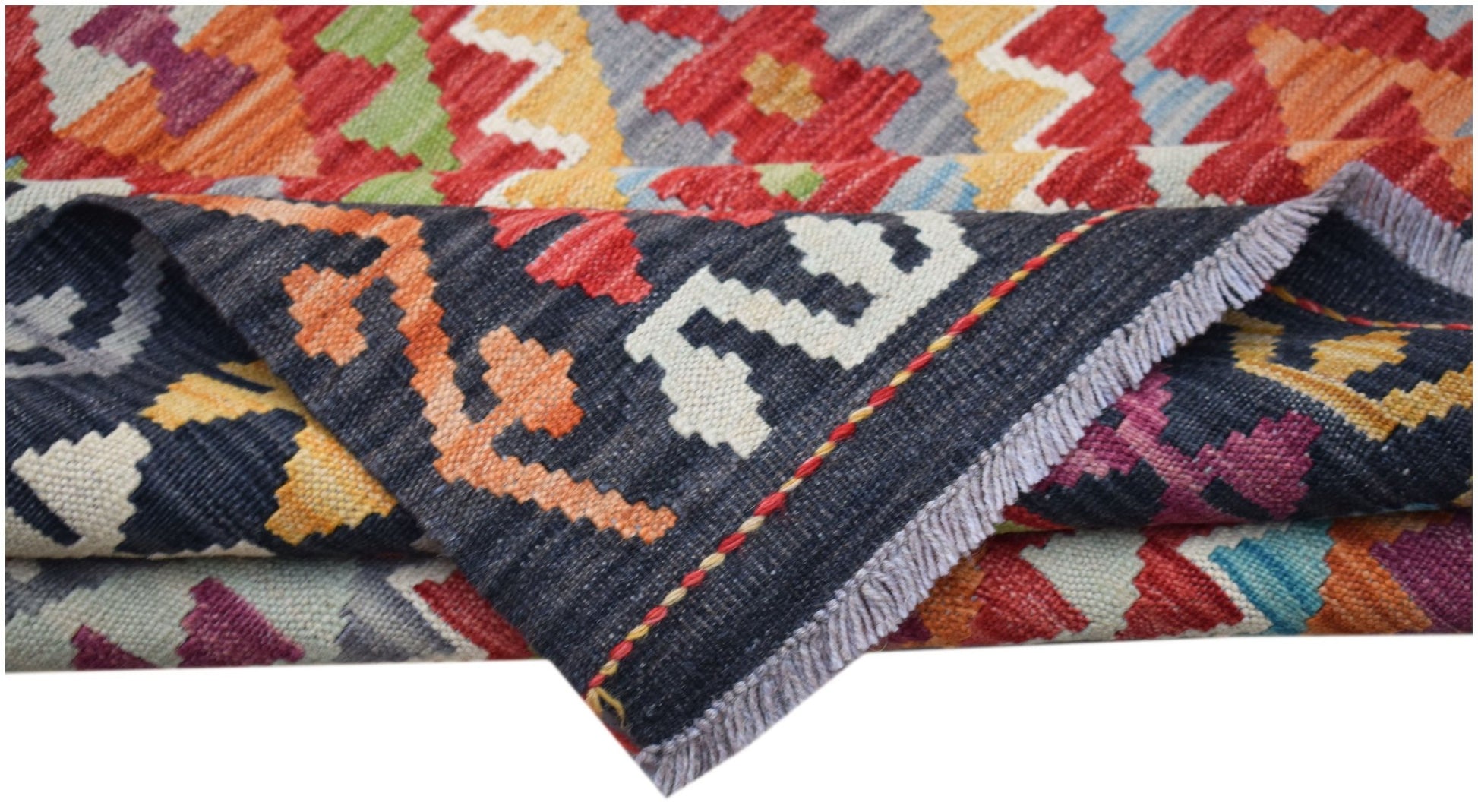 A handwoven Afghan Maimana kilim featuring a vibrant geometric pattern and flatweave texture.