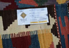 A handwoven Afghan Maimana kilim featuring a geometric pattern in vibrant wool colors.