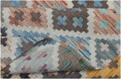 A handmade Afghan Maimana kilim rug featuring a geometric pattern in colorful wool.