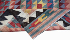 A handmade Afghan Maimana kilim rug featuring a geometric pattern in vibrant multicolored wool.
